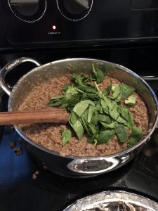 adding spinach to pot