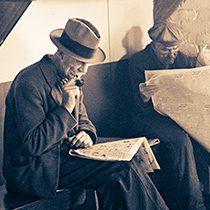 A man sits reading the newspaper