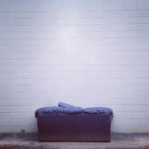 a white brick wall with a couch in front of it